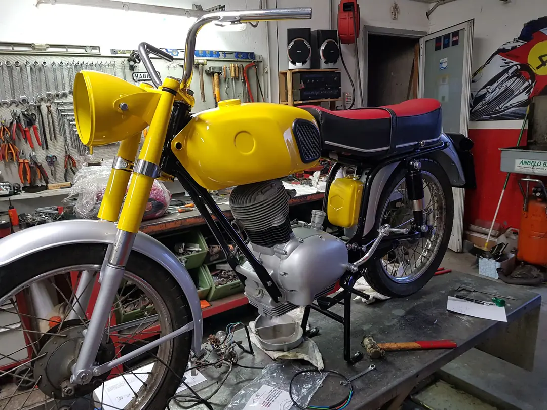 Moto d’epoca gialla in restauro sul banco dell’officina Paso Moto